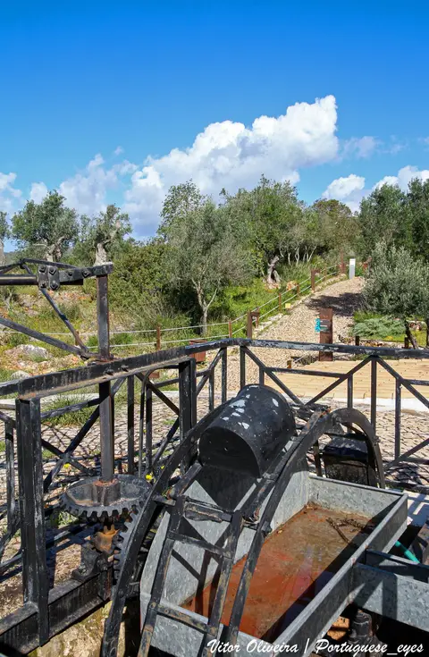Nora metálica antiga junto a caminho e oliveiras no Parque do Sítio das Fontes