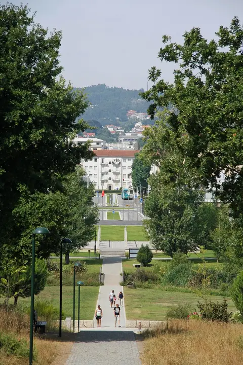 Alameda arborizada do Parque da Devesa em Vila Nova de Famalicão, com relvados e a cidade ao fundo