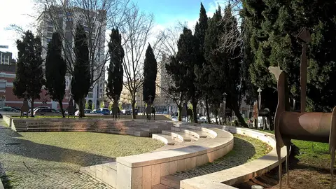 Jardim com anfiteatro de pedra, relva, ciprestes e esculturas de cavaleiros em metal
