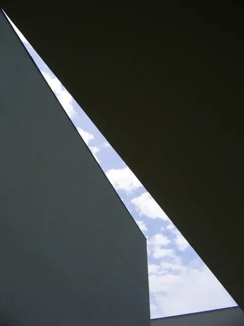 Pormenor arquitetónico minimalista do Museu de Serralves, com paredes brancas e uma fresta de céu azul