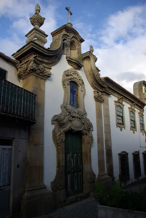 Fachada barroca em granito e branco da Casa Grande, com portal ornamentado e cruz no topo