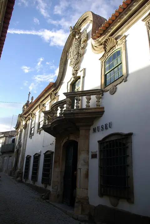 Fachada barroca branca da Casa Grande, com varanda em pedra e a palavra «Museu» na parede.