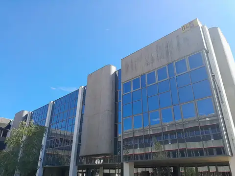 Edifício 4 do campus de Gualtar da Universidade do Minho, em betão e vidro, sob céu azul