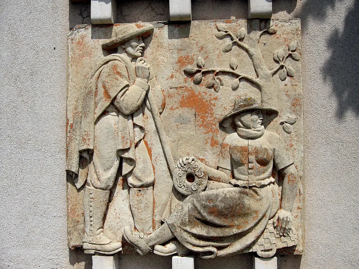Baixo-relevo em pedra na fachada do Museu de Arte Popular, com figuras de camponeses trajados