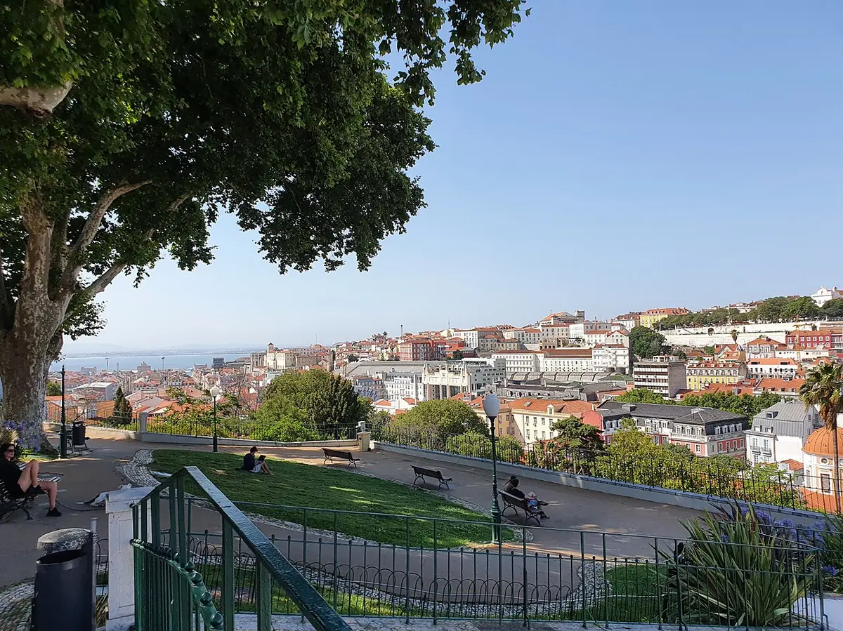Miradouro do Torel, em Lisboa, com relvado, bancos e vista sobre os telhados da cidade e o rio