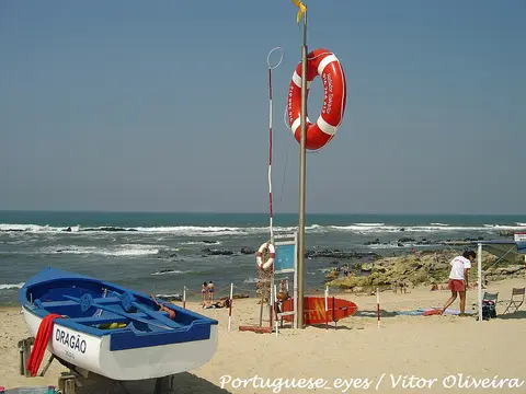 Praia de Miramar com barco salva-vidas, boia e posto de vigia junto ao mar