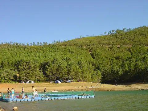 Praia fluvial de Fernandaires na albufeira de Castelo de Bode, com pontão flutuante e encosta arborizada
