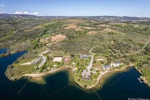 Vista aérea da praia fluvial da Fraga da Pegada, na albufeira do Azibo, rodeada de vegetação