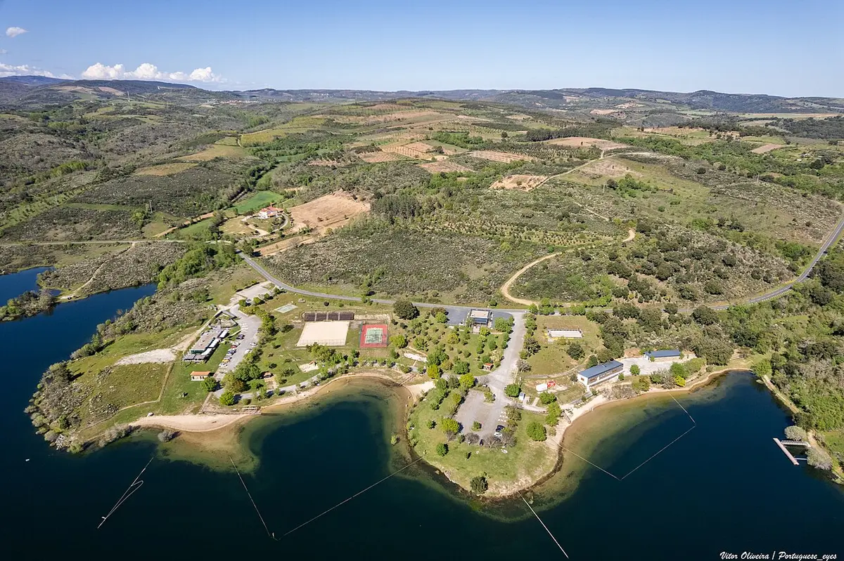 Vista aérea da praia fluvial da Fraga da Pegada, na albufeira do Azibo, rodeada de vegetação