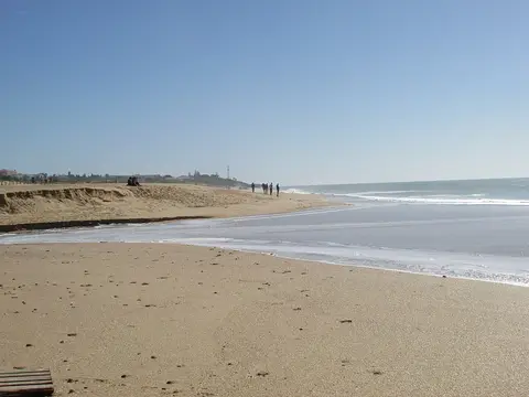 Praia dos Salgados com areal extenso, dunas baixas e mar calmo em dia de céu limpo