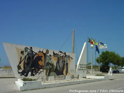 Monumento à Gente da Terra e do Mar, com mural colorido e bandeiras, na Praia de Quiaios