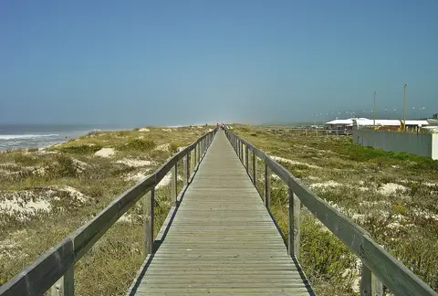 Passadiço de madeira sobre dunas a caminho da praia de Quiaios, com o mar à esquerda