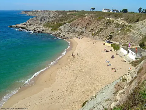 Praia de São Bernardino vista do alto da falésia, com areal em enseada e mar azul-turquesa
