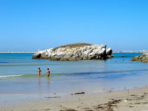 Praia do Baleal com duas crianças ao longe na água e ilhéu rochoso ao fundo