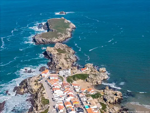 Vista aérea da península do Baleal, com casas brancas de telhados vermelhos rodeadas pelo mar