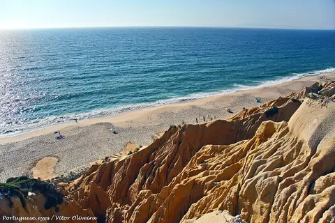 Vista do alto das arribas amarelas sobre a praia da Galé-Fontaínhas e o mar azul