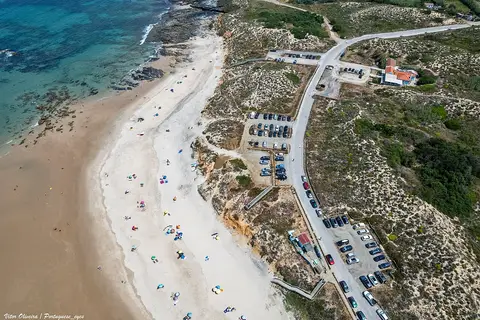 Vista aérea da Praia de Vale dos Figueiros, com areal, falésias e parque de estacionamento
