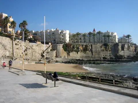 Praia da Azarujinha no Estoril, com passeio marítimo, arribas e edifícios ao fundo