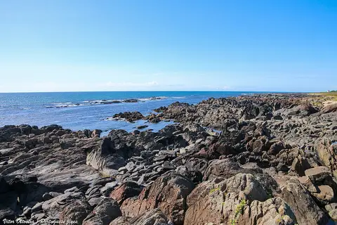 Costa rochosa da Praia Norte em Viana do Castelo, com mar azul e céu limpo