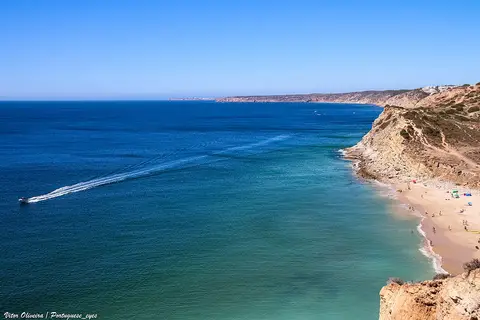 Vista elevada da praia da Boca do Rio, com falésias, areal e mar azul