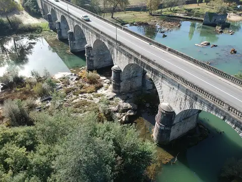 Vista aérea da Ponte do Bico, ponte de arcos em pedra sobre rio de águas verdes