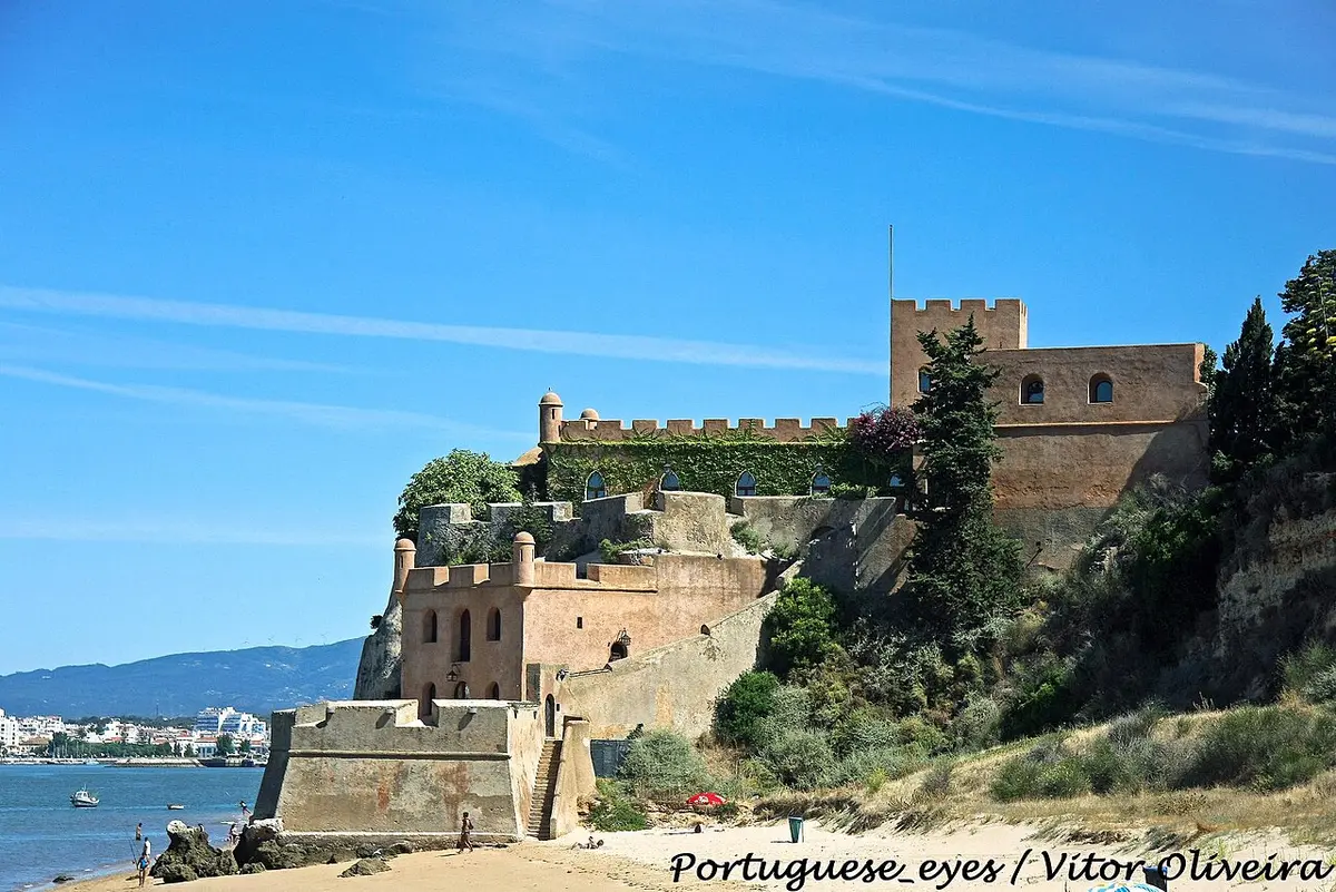 Forte de São João do Arade sobre a praia de Ferragudo, com o rio e o céu azul ao fundo