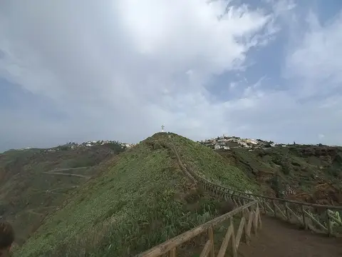 Trilho com vedação de madeira na Ponta do Garajau e estátua do Cristo Rei ao fundo