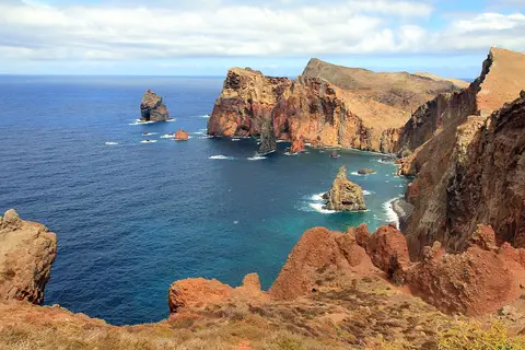Vista das falésias avermelhadas e do mar azul na Ponta do Rosto, Madeira