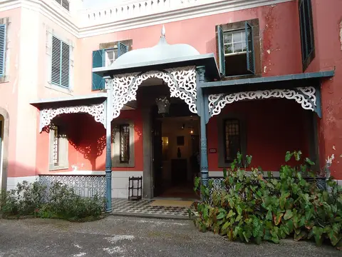 Entrada da Casa-Museu Frederico de Freitas, com fachada rosa e alpendre branco rendilhado