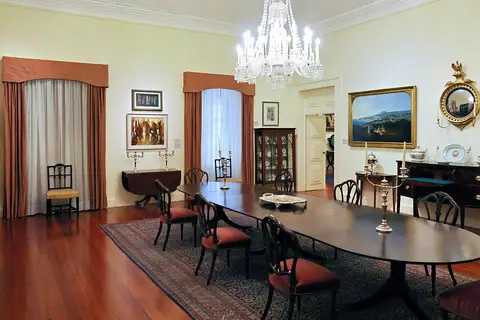 Sala de jantar do Museu da Quinta das Cruzes, com mesa antiga, cadeiras e lustre de cristal.