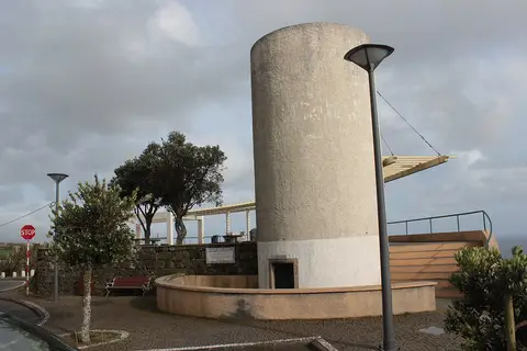 Miradouro do Caminho Novo com antiga torre cilíndrica em pedra, pérgula e bancos junto ao mar