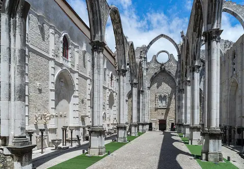 Nave sem cobertura do Convento do Carmo, em Lisboa, com arcos góticos e colunas de pedra