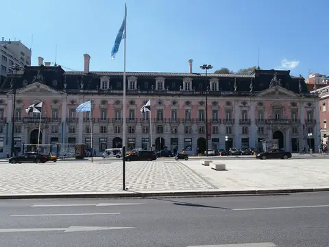 Fachada rosa do Palácio Foz, sede do Museu Nacional do Desporto, vista da praça com bandeiras.