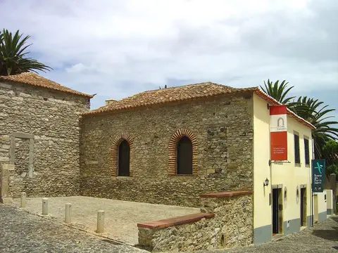 Casa Colombo em Vila Baleira, Porto Santo: edifício de pedra com janelas em arco e bandeira do museu.