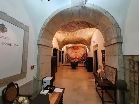 Interior do Museu Maynense: corredor abobadado em pedra com mobiliário antigo e sala de exposição ao fundo