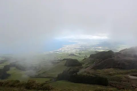 Vista panorâmica do miradouro do Pico do Paúl sobre campos verdes e costa com névoa