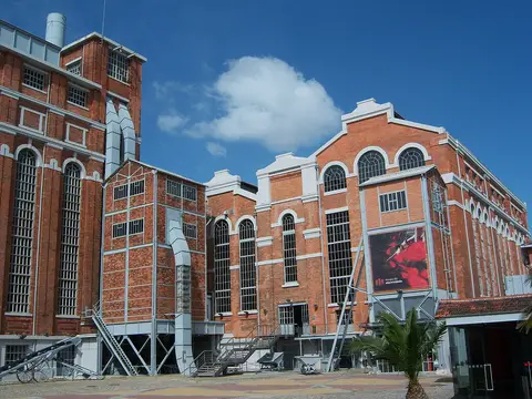 Fachada de tijolo da antiga Central Tejo, atual MAAT, sob céu azul
