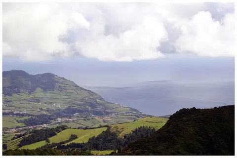 Vista do miradouro do Salto do Cavalo sobre campos verdes, aldeias na costa e o mar dos Açores.