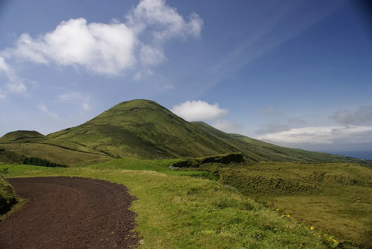Cone verde do Pico da Esperança na ilha de São Jorge, com caminho de terra e céu azul