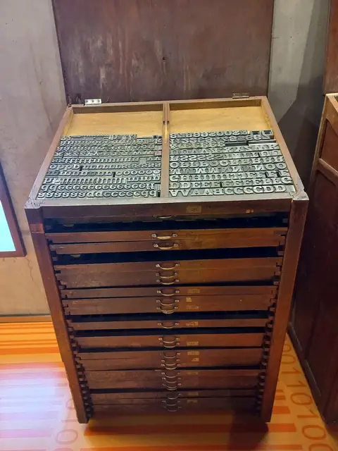 Móvel de madeira com gavetas e tipos móveis de metal em exposição no Museu da Imprensa da Madeira