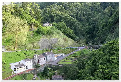 Vista aérea do Parque Natural da Ribeira dos Caldeirões, com casas de pedra e vegetação densa