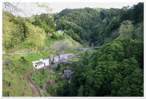 Vista aérea do Parque Natural da Ribeira dos Caldeirões, com moinhos e vegetação num vale verdejante