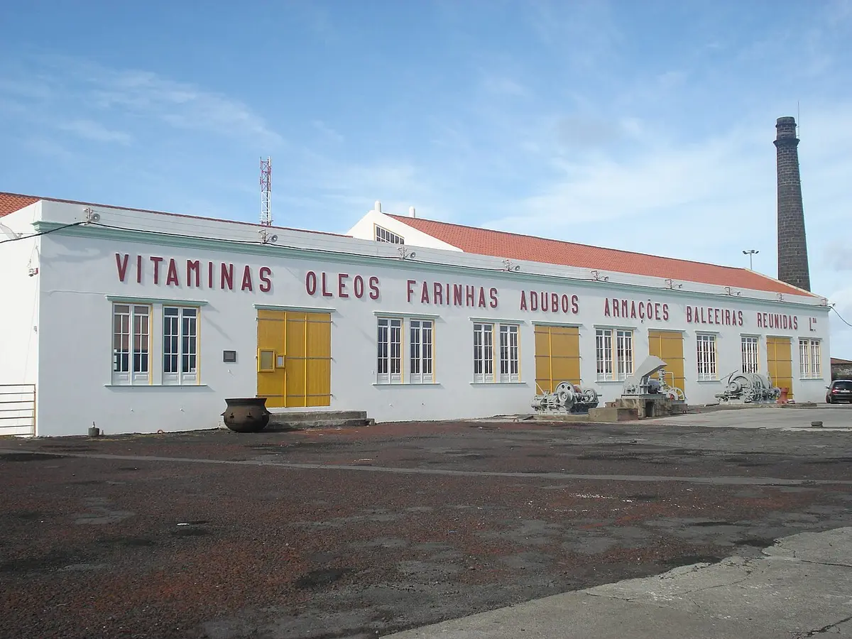 Edifício branco da antiga fábrica baleeira com letreiro vermelho e chaminé, São Roque do Pico