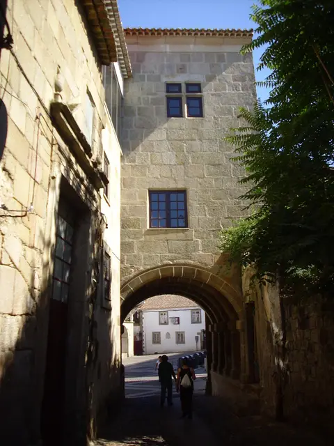 Casa do Arco do Bispo em Castelo Branco, com arco de pedra sobre a rua e janelas geminadas