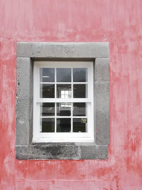 Janela de guilhotina com moldura de pedra datada de 1739 em parede cor-de-rosa da Casa das Mudas