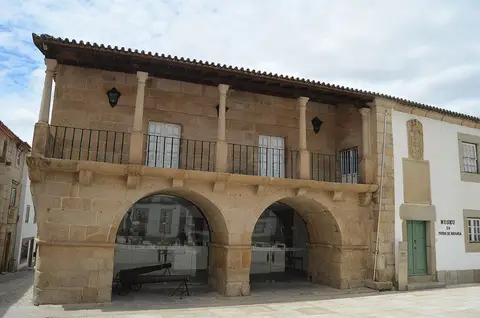 Fachada em pedra do Museu da Terra de Miranda, com arcadas, varanda e canhão sob os arcos