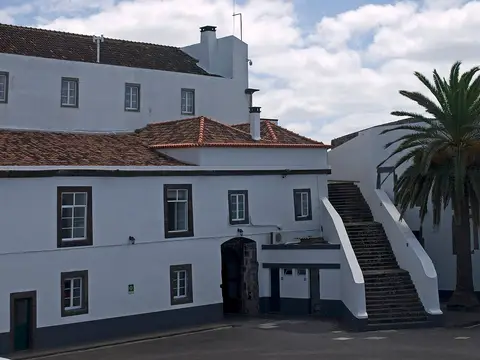 Edifício branco do Forte de São Brás com escadaria exterior e palmeira