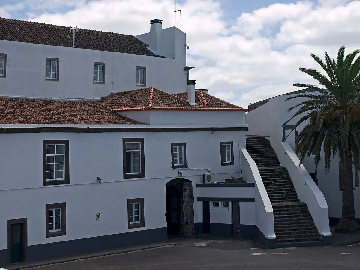 Edifício branco do Forte de São Brás com escadaria exterior e palmeira