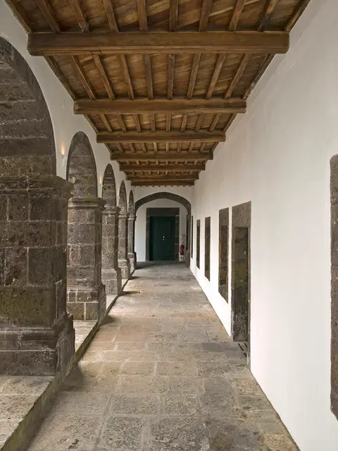 Galeria do claustro do Convento de Santo André, com arcos de pedra e teto de madeira