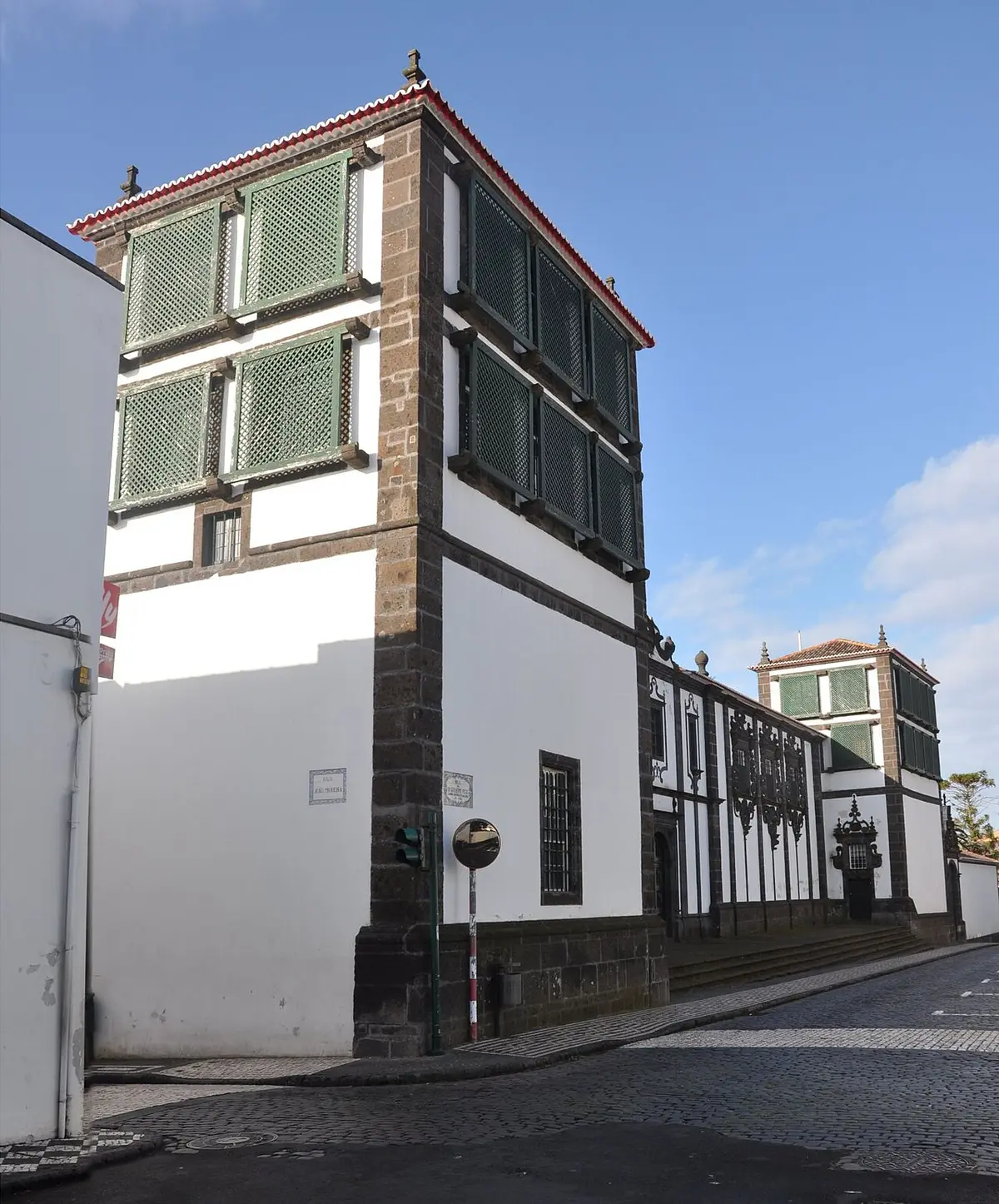 Fachada branca com pedra escura e janelas gradeadas do Museu Carlos Machado, Ponta Delgada